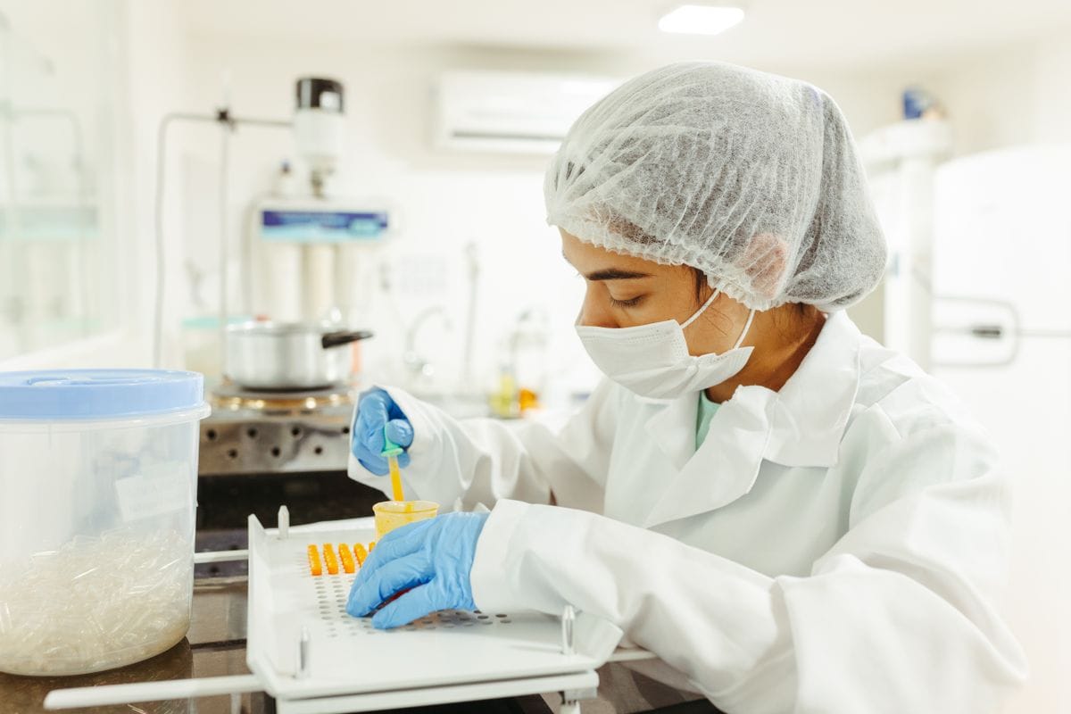 Production technician in protective clothing at a manufacturing bench (illustrative photo)